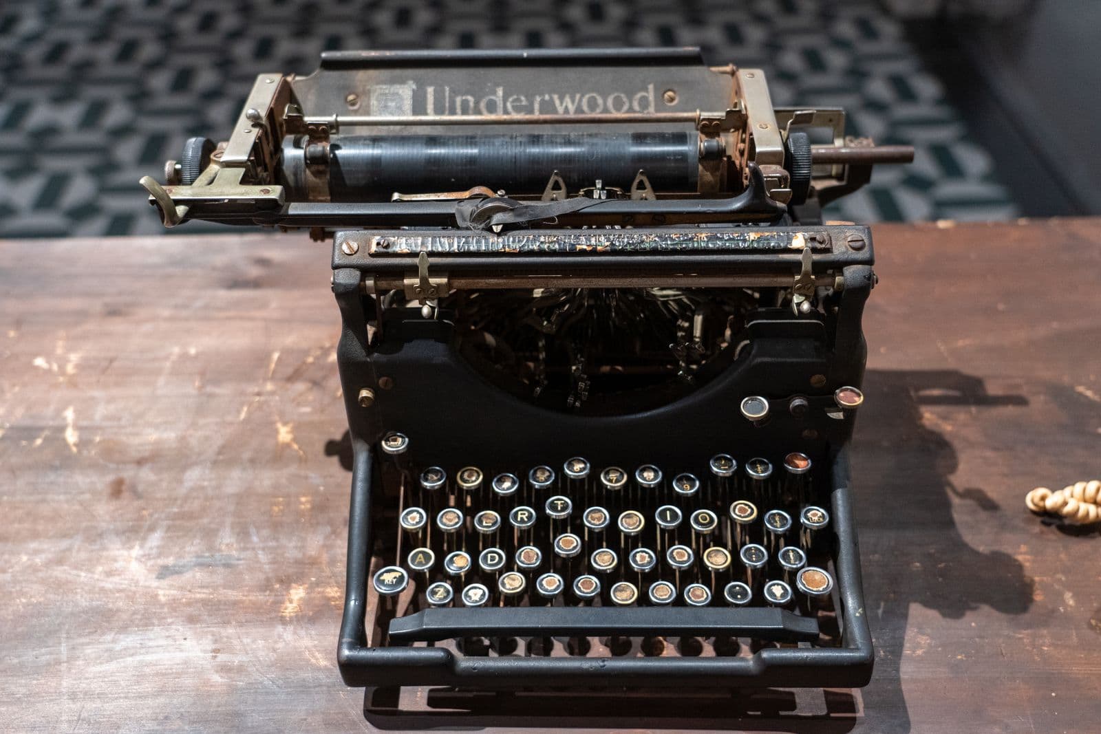 An antique typewriter on a wooden desk, from the era of telegrams that spelled out the word STOP instead of using punctuation