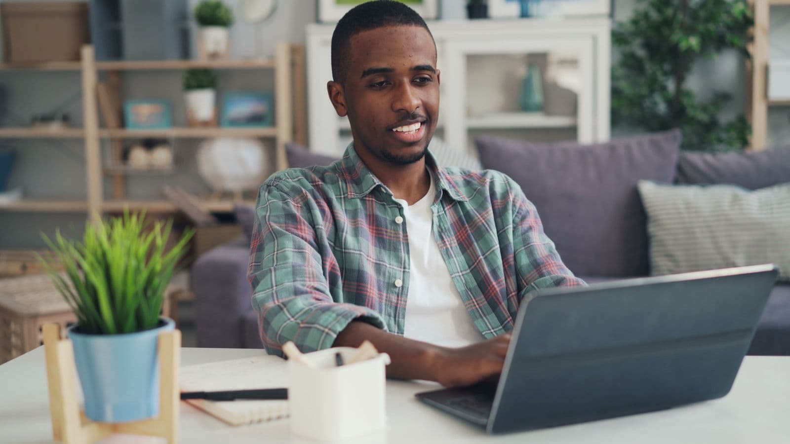Person dictating to a laptop at a bright desk